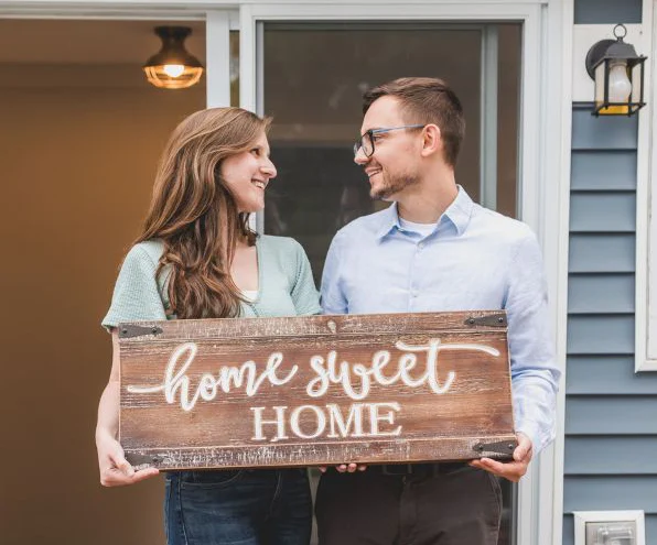 couple holding a hoe sweet home sign
