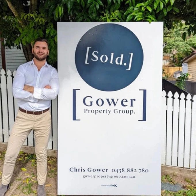 Chris Gower in front of a Sold sign
